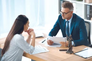 Professional lawyer reviewing certified translation documents with client in modern office setting.