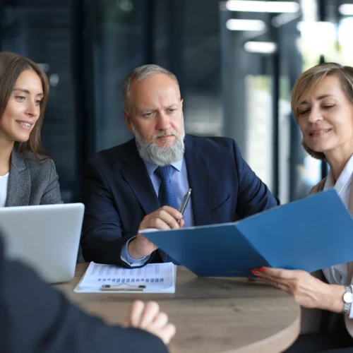 Professional business team reviewing official documents and reports in modern office setting