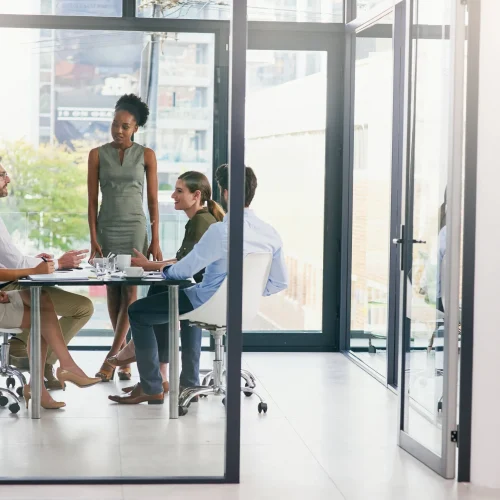 Professional team meeting in modern office discussing certified translation services and USCIS document requirements.