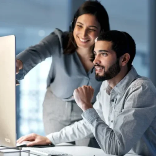 Professional team collaborating on certified translation documents at modern office workspace with computer.