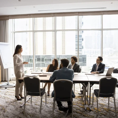 Professional business team meeting in modern office with presenter discussing certified translation services.