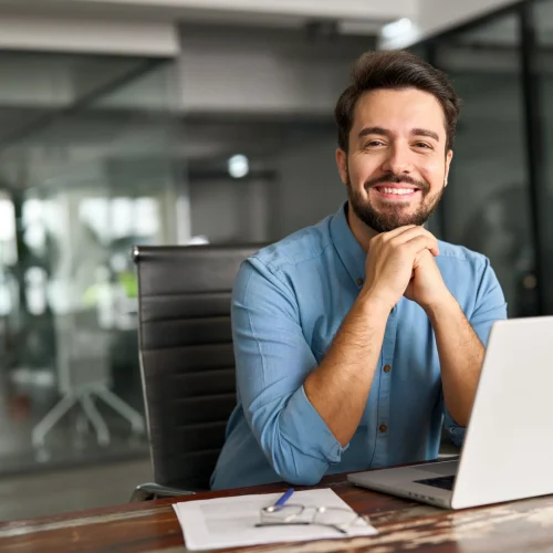 Professional translator working at desk with laptop and documents in modern office environment.